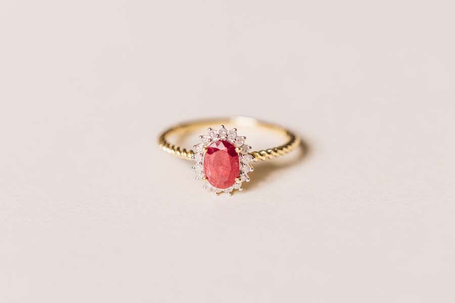 Halo Ring with .13 Carat TW of Diamonds and 7x5MM Oval Ruby 10kt Yellow Gold