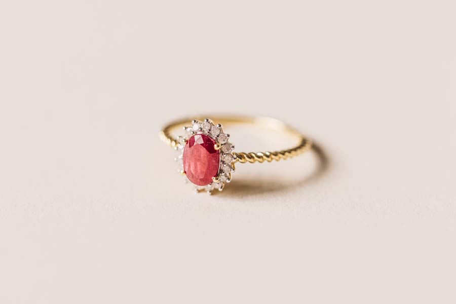 Halo Ring with .13 Carat TW of Diamonds and 7x5MM Oval Ruby in 10kt Yellow Gold