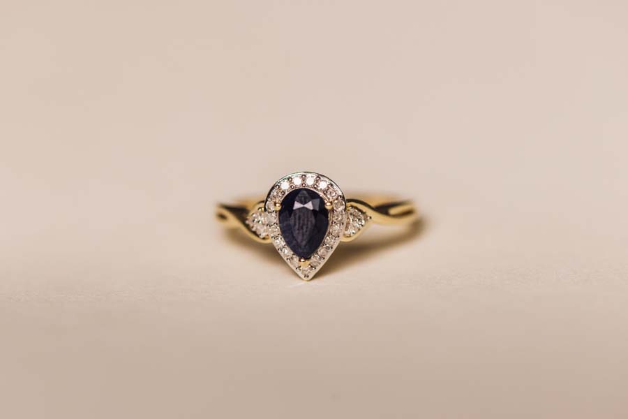 Halo Ring with .17 Carat TW of Diamonds and 7x5MM Pear Shape Blue Sapphire in 10kt Yellow Gold