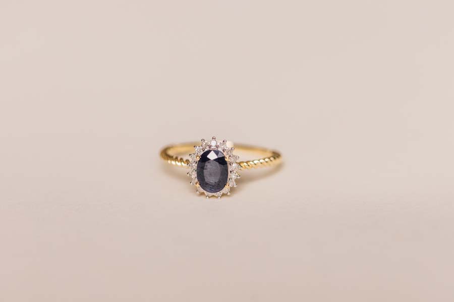 Halo Ring with .13 Carat TW of Diamonds and 7x5MM Oval Blue Sapphire in 10kt Yellow Gold