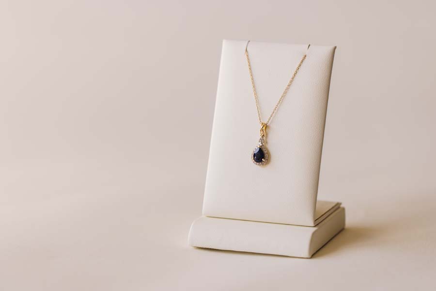 Halo Pendant with .13 Carat TW of Diamonds and 7x5MM Pear Shape Blue Sapphire 10kt Yellow Gold Chain